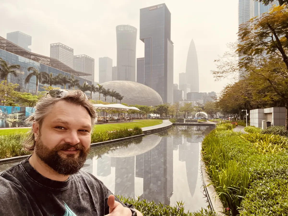 Aragorn Meulendijks giving a thumbs-up in front of the Shenzhen skyline